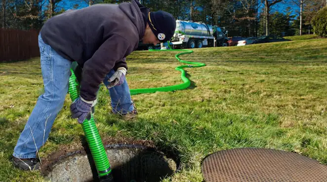 Service technician performing residential septic pumping and drainage maintenance in Richmond, VA